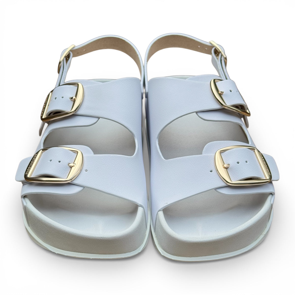 Pair of white ANATOMICA sandals with gold buckles on a white background